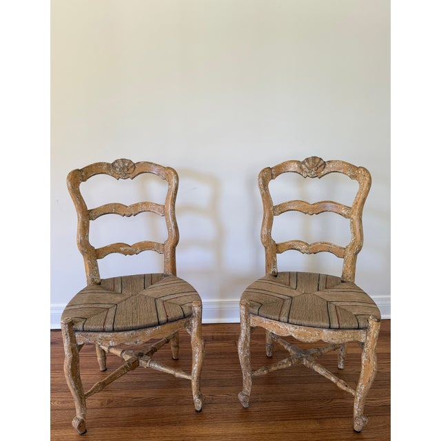 A pair of Mid 20th C French Provincial Revival style ladder back dining chairs with craquelure painted hardwood, painted...