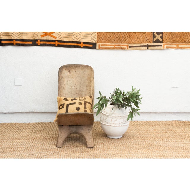 Experience the allure of West African craftsmanship with this unique hand-carved folding chair, often referred to as a...