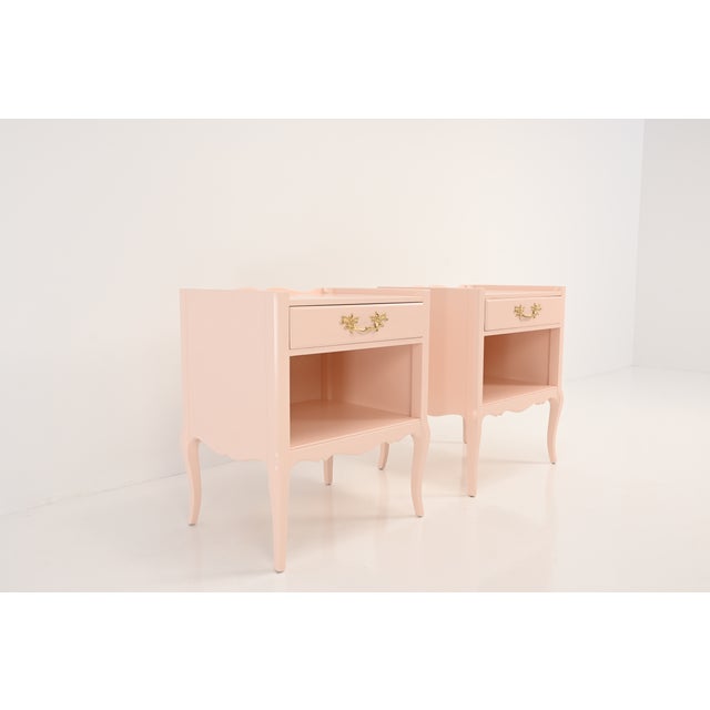 This elegant pair of vintage Henredon nightstands has been professionally refinished in the soft, romantic blush pink of...