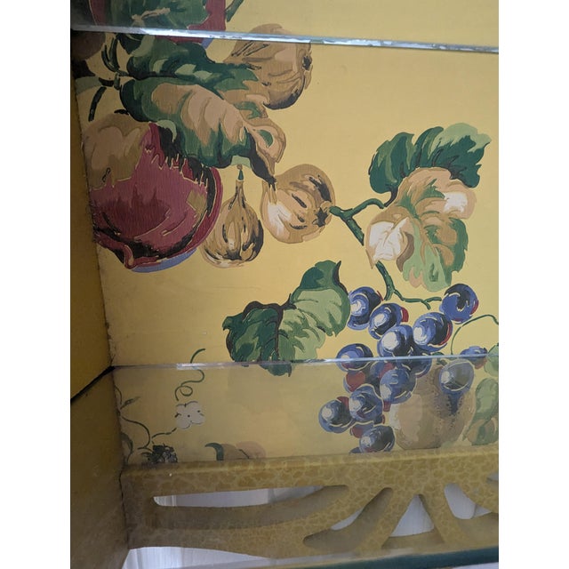 Yellow wood display with curved scrollwork at top and bottom. Hand painted vintage wallpaper back. 2 glass shelves. Towel...