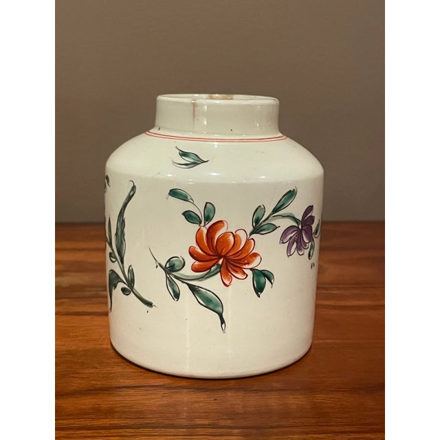 This charming creamware pottery tea caddie is hand decorated with floral designs of single flowers and leaves from England...
