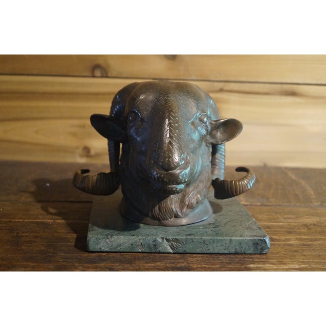An antique bronze ram head which is mounted on a marble base. This piece is very heavy duty, and comes from an old mansion...