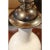 A large ceramic vase in white with stainless steel handles and a silver leaf lid with a bold turned stainless steel finial.