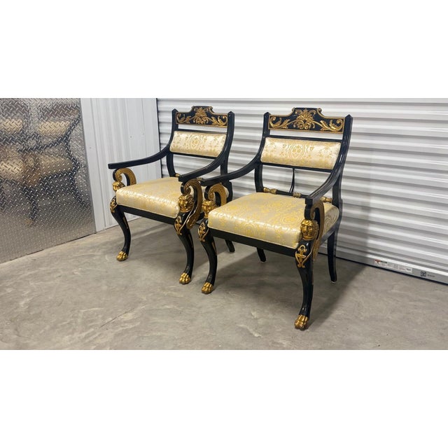 A dramatic pair of vintage Italian Hollywood Regency armchairs inspired by French Empire design. These striking chairs...
