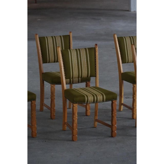 A beautiful set of six sculptural dining chairs in solid oak by Henning (Henry) Kjærnulf, Denmark, 1960s. The chairs carry...