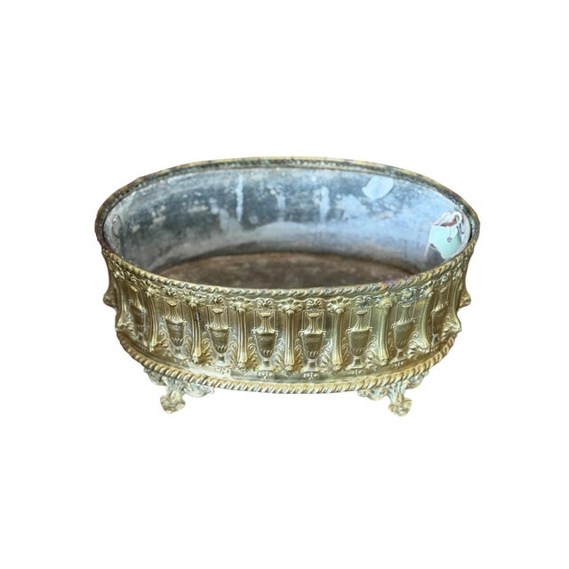 This is an elegant 19th century French jardiniere (planter), made of brass with finely detailed repousse' details. The...