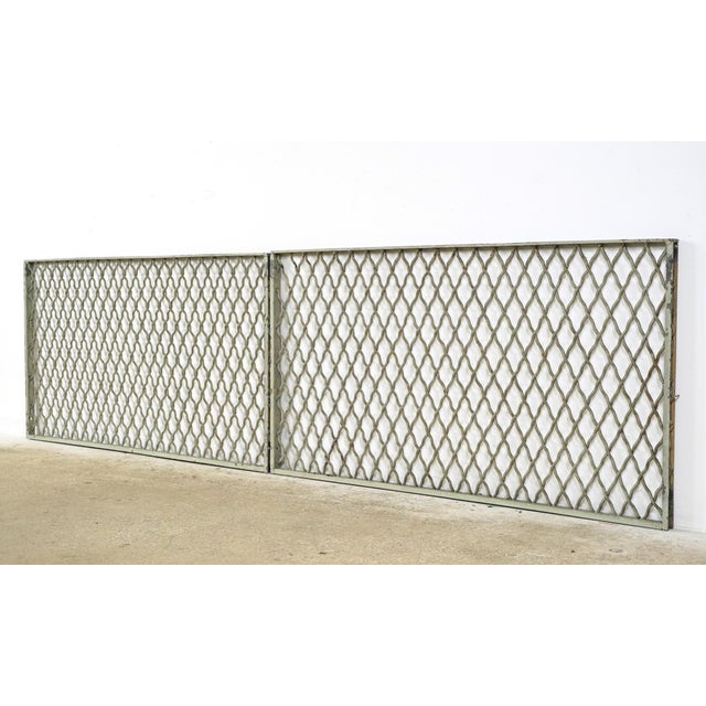 Industrial style tan and gray painted steel security panels made of woven wire in a diamond pattern with a rectangular...