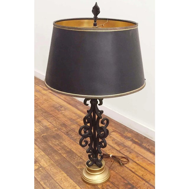 Vintage Mediterranean style wrought iron table lamp with brass toned base. Black 'starter' shade with gold lining.