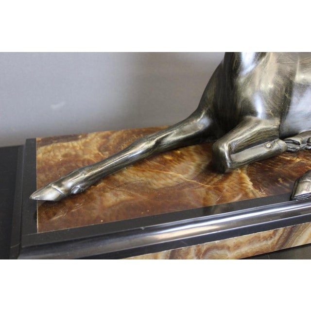 Sculpture in regula representing an antelope lying on a base in onyx and black marble, Art Deco period, original patina,...