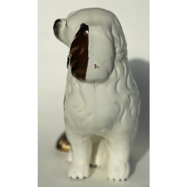 A 19th-century English Staffordshire spaniel dog, hand-painted with traditional detailing and historic charm. This...