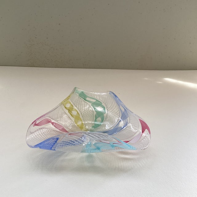Classic Zanfirico Murano hand blown dish with twisting ribbon swirls in multiple colors upon a white net background....
