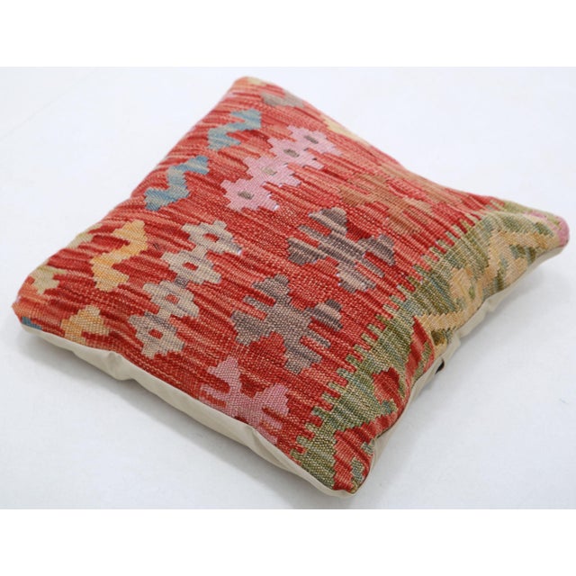 A one-of-a-kind handwoven Afghan wool kilim accent pillow featuring stacked stepped diamonds on a deep red ground. Cut and...
