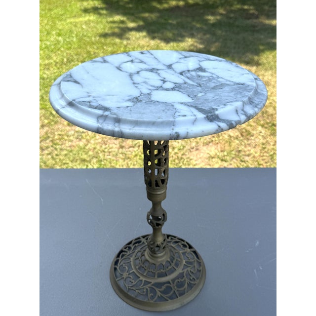 Offering for sale this exceptional vintage pedestal table featuring a white Italian marble top with gray veining and an...