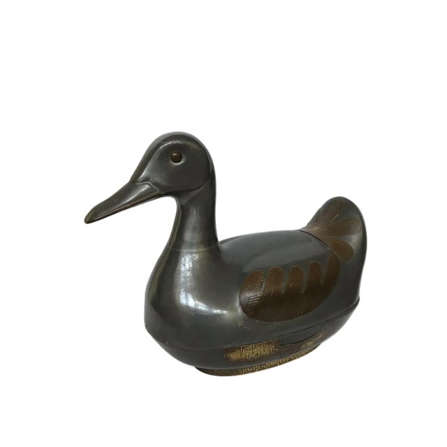 The duck is made of pewter with brass trimming. It is a charming lidded box with finely detailed features. The eyes, beak,...