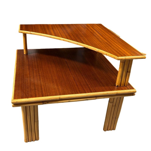 This beautifully restored two-tiered corner side table with vertically stacked legs and a dark-stained mahogany top. The...