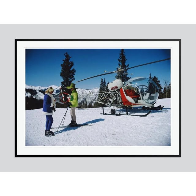 Portofino' by Slim Aarons Open Edition Two fashionably attired women stand in the foreground of a snowy landscape with a...