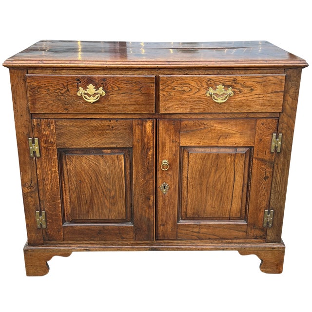 Made in England during the late 19th century, this Georgian-style oak cupboard is full of old-world charm and beautiful...