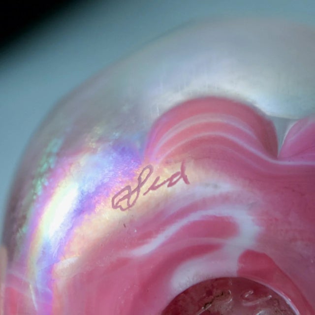 Whimsical art glass paperweight by Joe St. Clair featuring a sulfide encased Kewpie doll floating on a soft pink cloud...