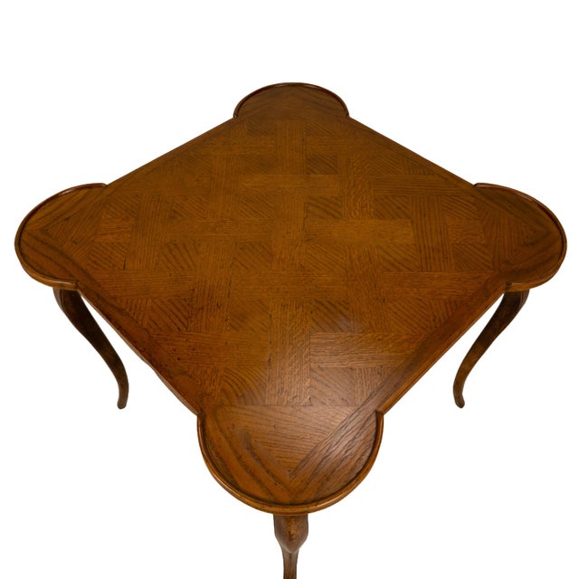 A vintage Italian card table crafted in oak, featuring a parquetry veneer top with a cross pattern that adds character....