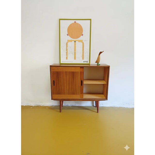 A vintage Danish teak sideboard from the 1950s with sliding doors and an elegant, compact design, perfect for a functional...
