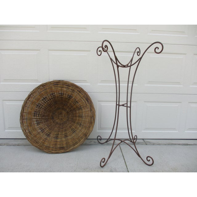 Simple scrolled lines adorned with a large wicker basket on top. This wrought iron planter is large at 47 inches in height...