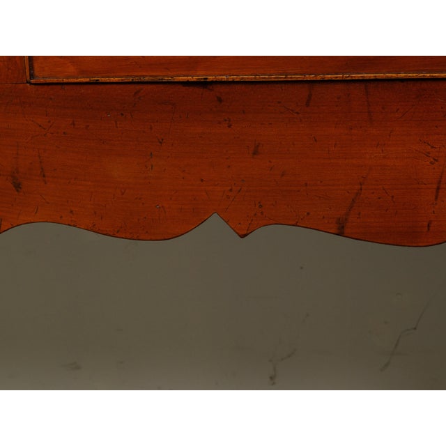 An English walnut or yew wood dresser base from the mid 20th century, with three drawers and carved apron. Created in...
