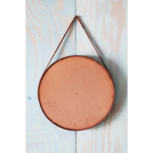 A danish mid century modern mirror featuring a beveled finger jointed teak frame. The mirror hangs form a thin leather...