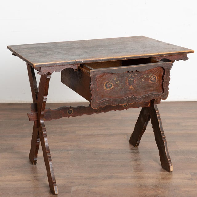 This side table is both unique and charming, thanks to the original painted finish and the decoratively carved trestle "X"...