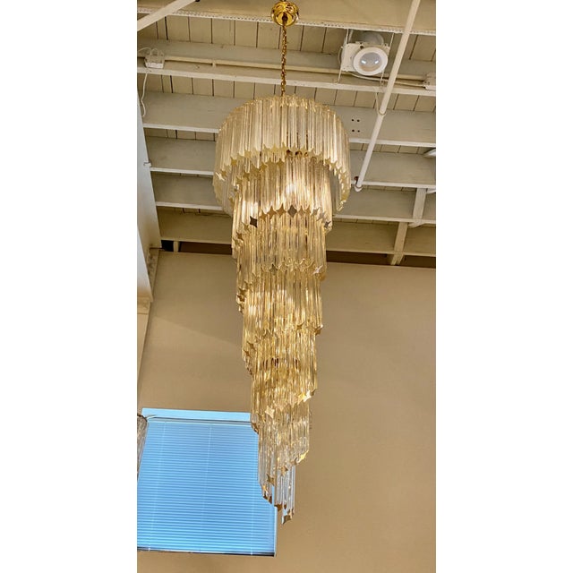 Stunning Mid-Century Modern Italian spiral chandelier. Each of the prisms are solid glass. They hang from hooks onto a...
