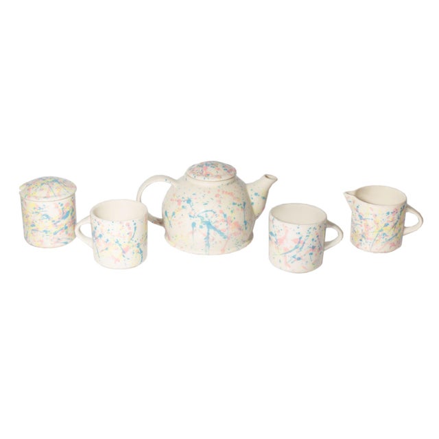 A Postmodern ceramic tea set by Feltman Langer. The hand-painted set has a blue, pink, and yellow splattered design...