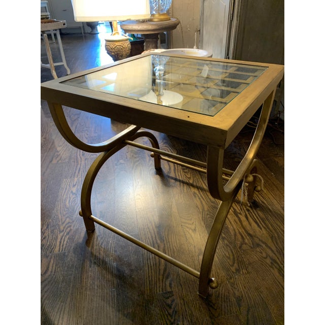 Vintage metal table touched in gold leaf. Has a glass top.