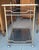 Mid-century modern silver tone bamboo style bar cart. Featuring two levels of smoked glass shelving on four wheels and a...