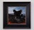 The artwork depicts a figure poised on the edge of a rocky landscape, embodying the myth of Icarus with dark, feathered...