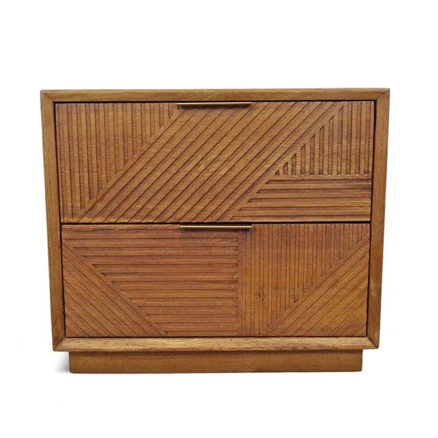 Modern oak wood and iron nightstand with carved linear angular pattern on two drawers. Bronze finish iron hardware. Each...