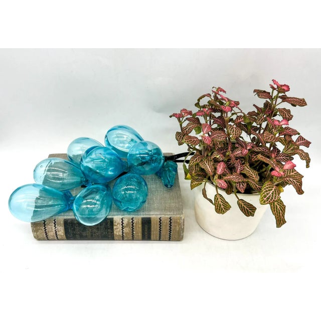 Stunning, oversized handblown glass grapes wired together to form a cluster. Features matching leaves and gorgeous...
