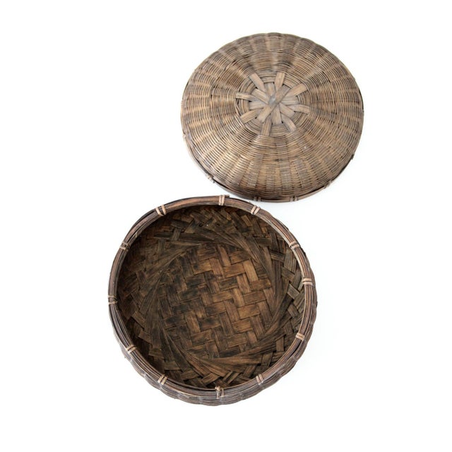 A beautiful vintage Chinese woven basket featuring a domed lid, rich dark finish, and finely crafted bamboo construction....
