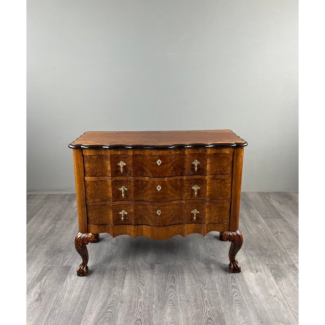 A beautiful Louis XV style chest of drawers in burr walnut veneer, made in the first half of the 20th century. It is...