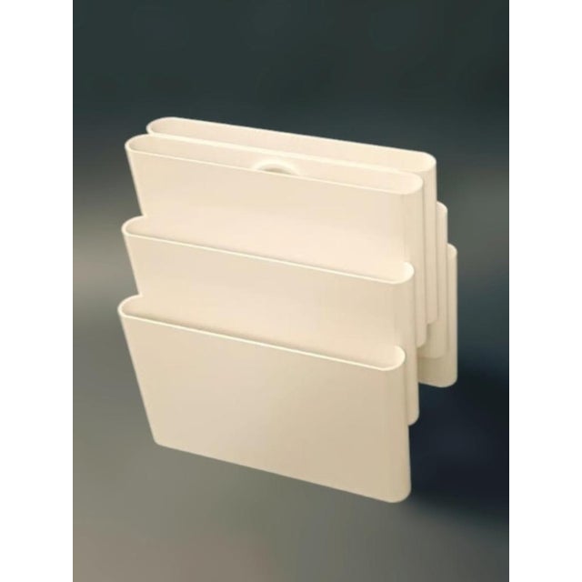Vintage Italian mid-century white plastic magazine rack with six compartments and a round handle, designed by Giotto...