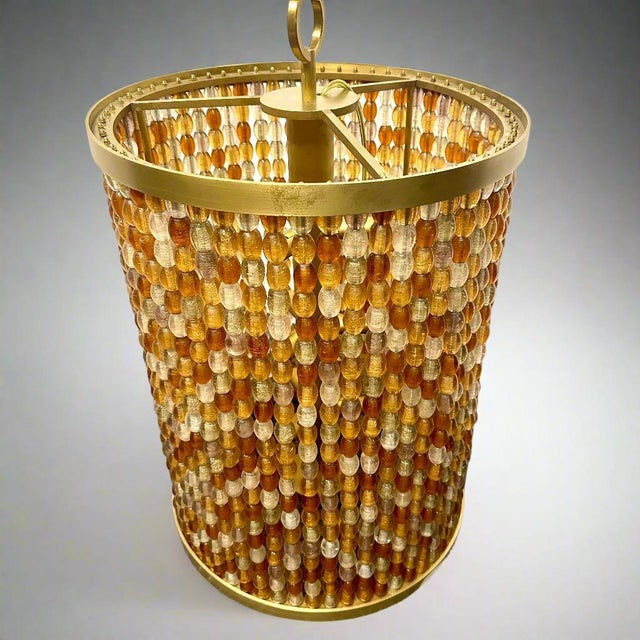 A Contemporary Modernist Lantern designed by Roland Wolff. Crafted in gilt bronze with Hand-Blown Murano Crystal Beads of...