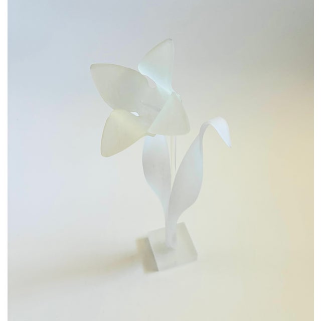 A vintage lucite flower sculpture. The flower, leaves, and base have a frosted finish with a clear lucite stem. A...