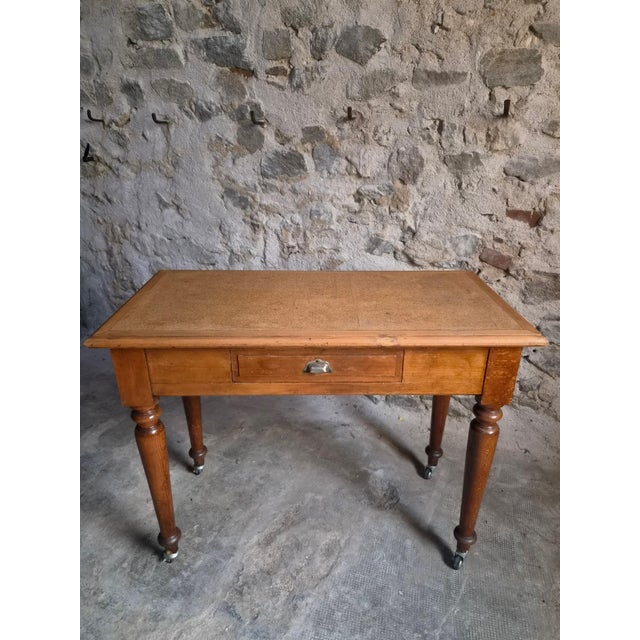 This vintage beechwood office desk features a rectangular top with an inset linoleum writing surface and a single drawer...