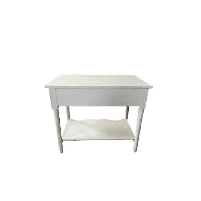 A painted bamboo table that has been restored from the early 21st century. This is a rectangular table that is white with...