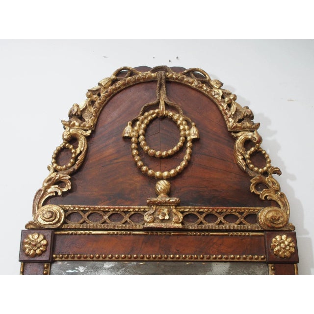 A stunning 18th century mahogany and gilt mirror, the frame with rosettes and beaded molding and over fluted, tapered...