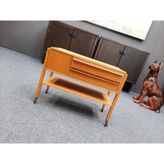 A very fine sewing table from the mid-1960s. It stands on four intact casters. It has two drawers and ample storage space...
