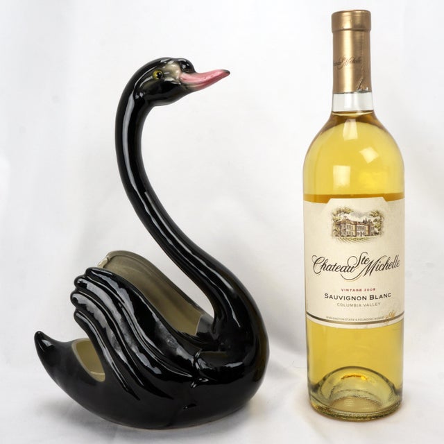 A Maddux black swan planter that appears to have never been use as a planter. The planter is shaped like a swan swimming...