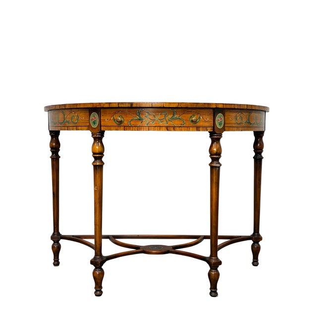 Elegant Neoclassical-style demilune console table featuring a warm golden wood finish with elaborate polychrome painted...