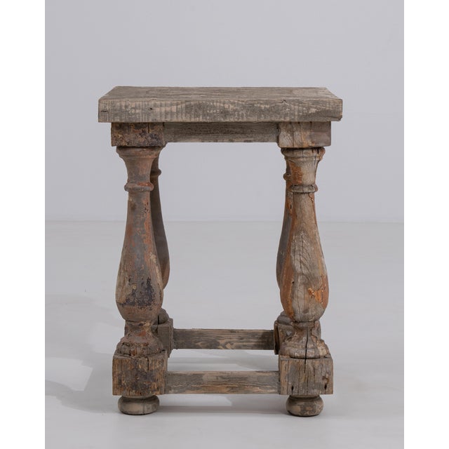 A 20th century French pedestal table crafted in wood, featuring turned legs connected by a shaped stretcher base. The...