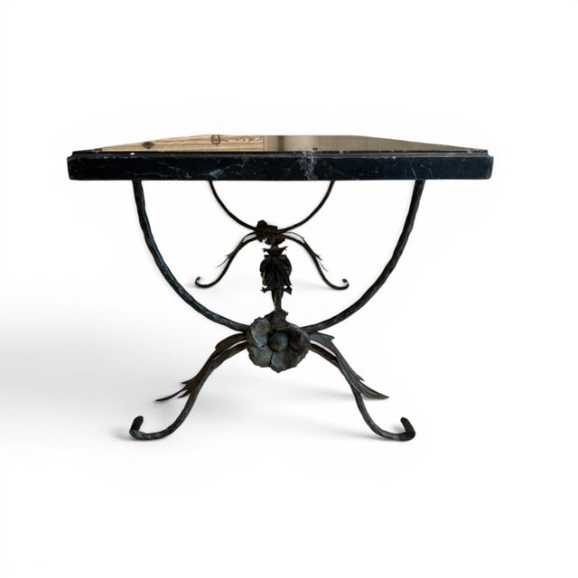 This striking coffee table features a sculptural bronze leaf base paired with a richly veined black marble top, creating a...