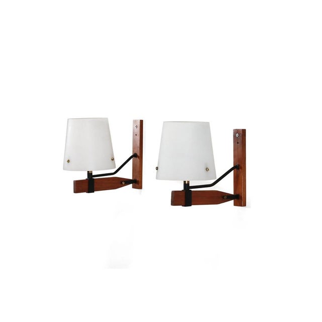 This set of two Italian designer wall lamps is from the 1950s manufacturer Esperia. The lamps feature a sleek teak wall...