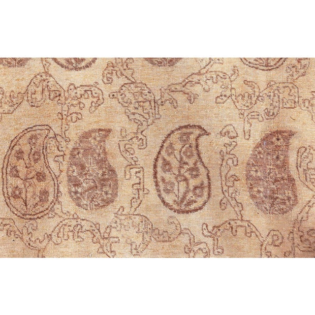 A late 19th century Persian Tabriz carpet, the sand field with delicate vinery and rows of brown and sand botehs overall...